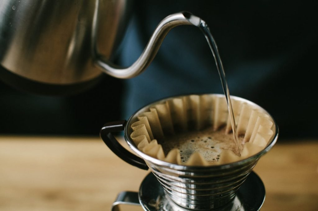 full-filled-coffee-stainless-steel-cup-1879322 Close-up of a manual pour over coffee brewing process, highlighting the coffee and filter.